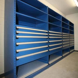 Blue Rousseau spider shelving system that is empty in a warehouse setting.